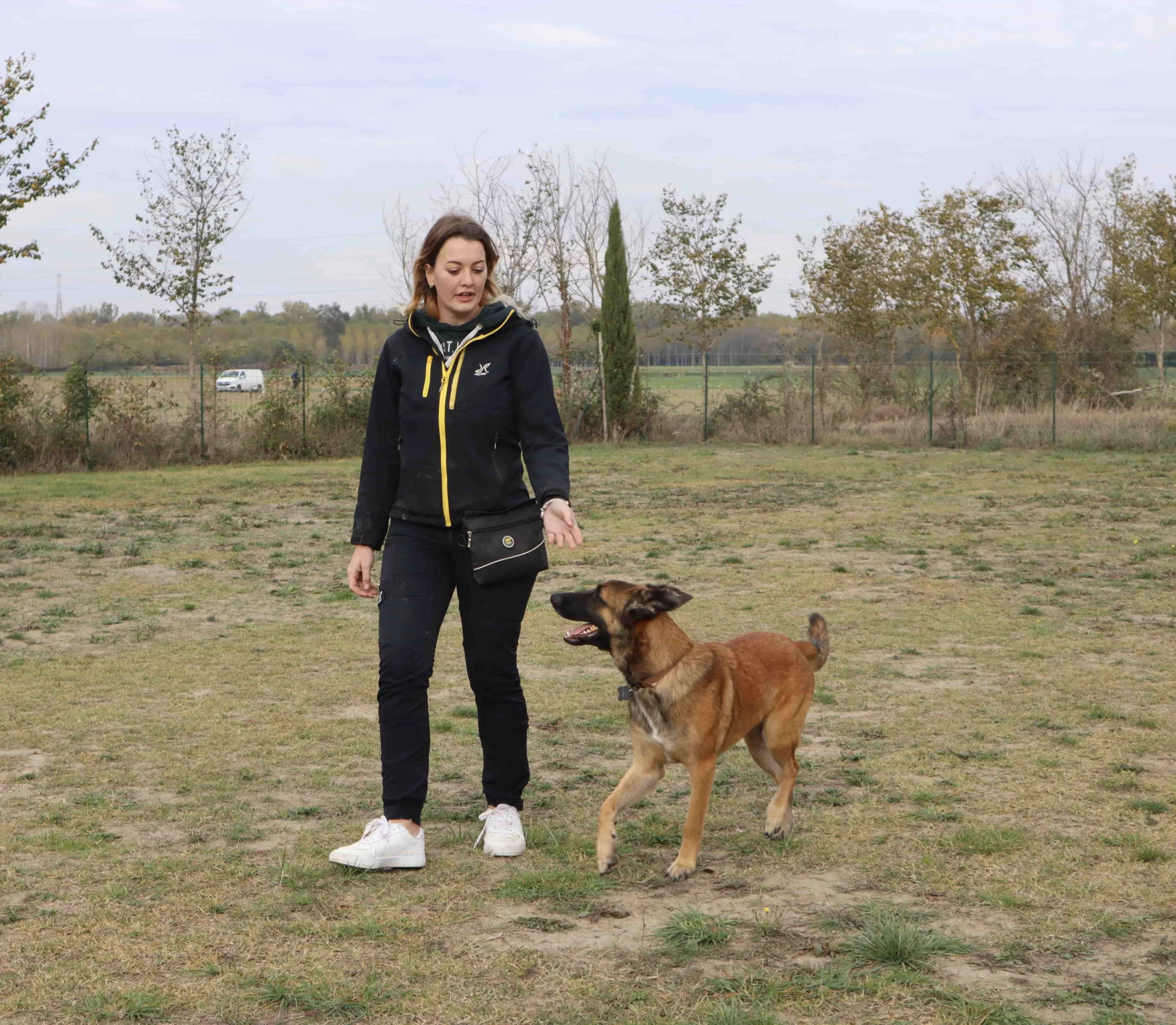 Une étudiante en train de promener son chien, montrant l'importance de la formation pour renforcer la relation entre les propriétaires et leurs animaux