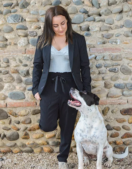 Une jeune femme en train de câliner son chien, montrant l'importance de la relation entre les propriétaires et leurs animaux